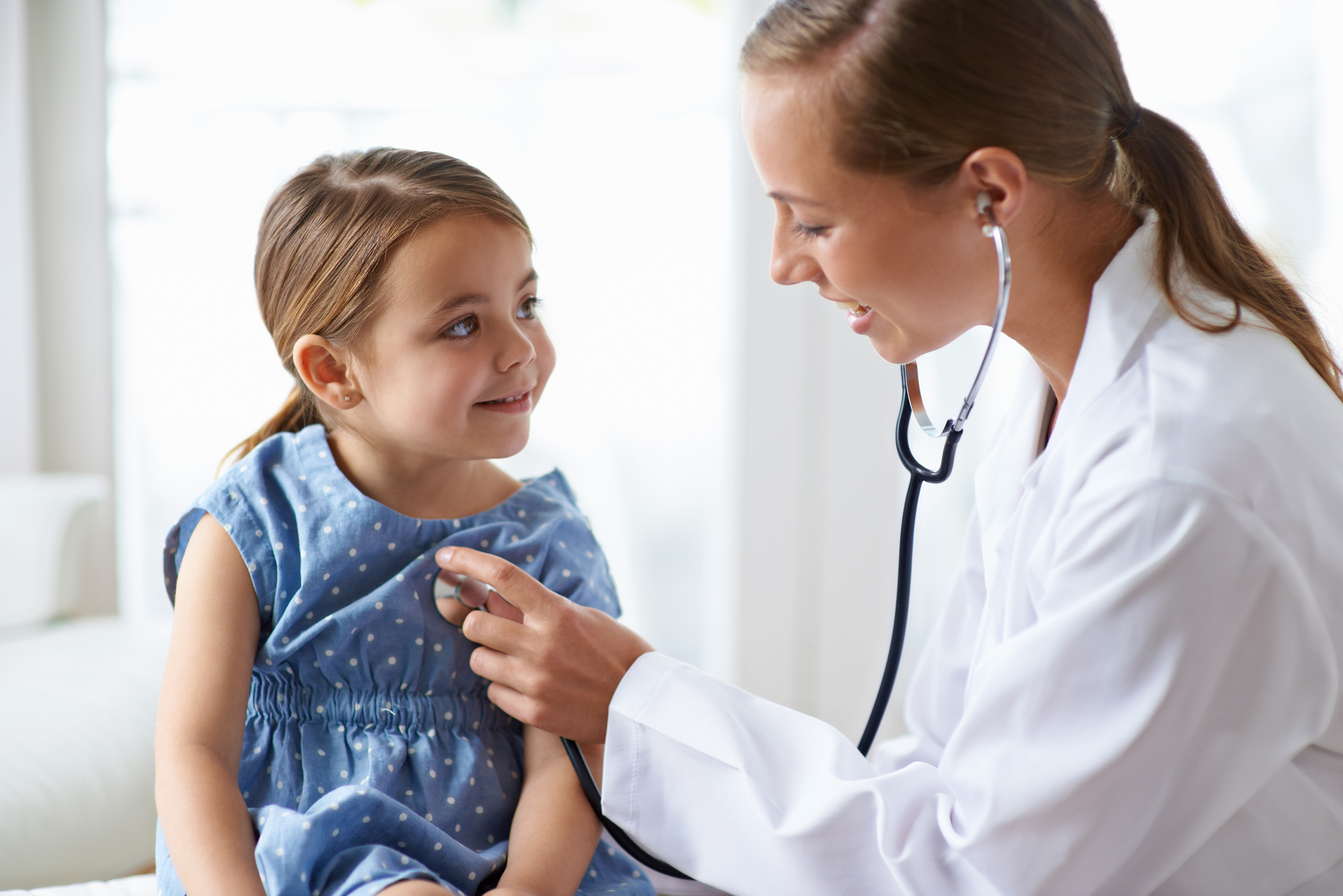 Getting her yearly check-up Doctor Listening to Young Girl's Heart beat.